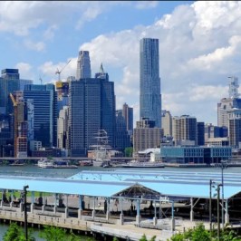 a bridge over a body of water with a city in the background